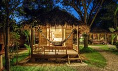 a small wooden cabin with a hammock in the front yard at night time