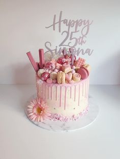 a birthday cake with pink frosting and decorations