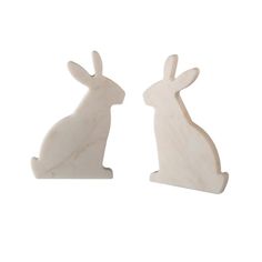 two white marble rabbits sitting next to each other on a white background, one is facing the opposite direction