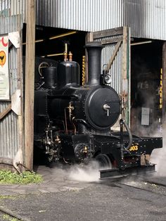 an old fashioned steam engine sitting in front of a building