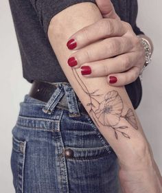 a woman's arm with a flower tattoo on the left side of her arm