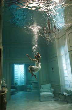 a woman is floating in the air under water