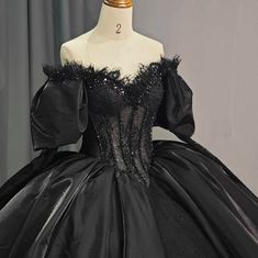 This luxurious black party ball gown boasts a dazzling beaded corset-style bodice adorned with delicate lace and topped with puffy off-the-shoulder sleeves. The princess waist and full ball gown skirt, complete with a train, create a regal silhouette. The ribbon lace-up back adds a touch of sophistication and allows for a customized fit. a line ball gown style: formals color as shown built in bra sweetheart neckline train as shown lace up back Quncie Dresses Black, Ballroom Extravaganza, Princess Quinceanera Dresses, Black Quince, Champagne Quinceanera Dresses, Beaded Corset, White Quinceanera Dresses, Purple Quinceanera Dresses, Black Quinceanera Dresses