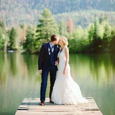 a bride and groom kissing on a dock