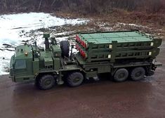 an army truck is parked on the side of a road in front of some snow