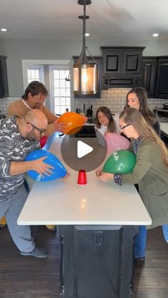 a group of people standing around a kitchen island