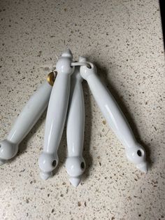 three white ceramic vases sitting on top of a counter