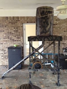 a large metal object sitting on top of a wooden floor next to a brick wall