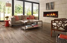 a living room filled with furniture and a fire place in front of a large window