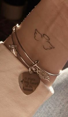 a person wearing a bracelet with a heart shaped charm on their wrist and an inscription that says