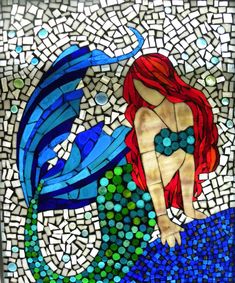 a stained glass mermaid sitting on top of a blue fish