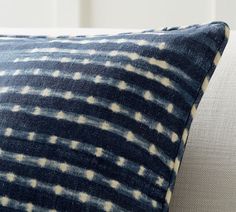 a blue and white pillow sitting on top of a couch