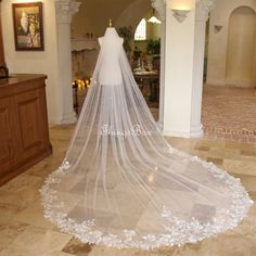 a wedding veil is on display in a room with stone flooring and arches around it