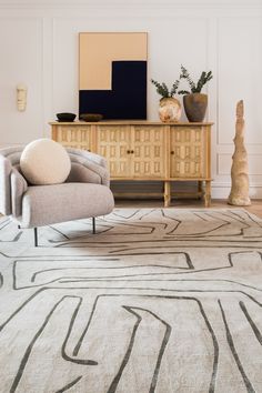 a living room with a large rug and two chairs