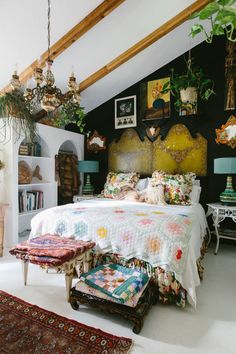 a bed sitting in a bedroom next to a book shelf filled with books and plants