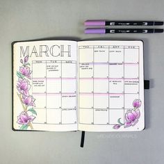 an open planner with flowers on it next to two markers and a pen that says march