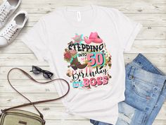 a t - shirt with the words stepping into 50 birthday is boss on it next to jeans and shoes