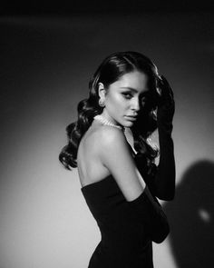 a black and white photo of a woman with long hair wearing a strapless dress