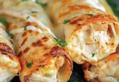 chicken and cheese spring rolls on a plate with parsley sprinkled around the edges