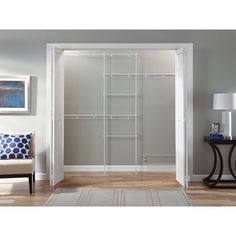 an open closet with white shelves and doors