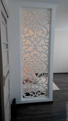 an open door with intricate carvings on the front and side panels in white painted wood