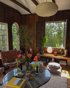 a living room filled with furniture and lots of plants on top of a coffee table