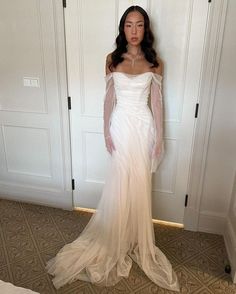 a woman in a white dress standing next to a closet