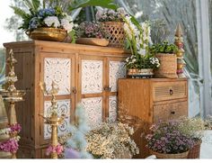 a wooden cabinet filled with lots of flowers