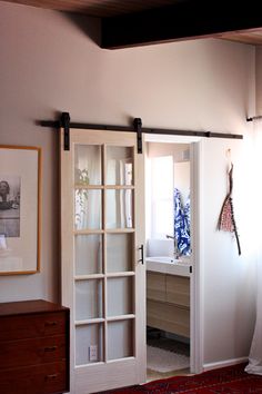 an open sliding door in a bedroom next to a dresser and mirror with the words made - to - order sliding doors on it