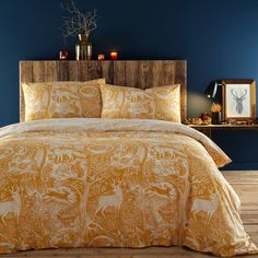 an image of a bedroom setting with deer and trees on the comforter bedding