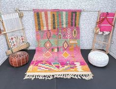 a colorful rug is sitting on the floor next to two stools and a chair