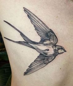 a bird tattoo on the back of a woman's stomach