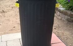 a black trash can sitting on top of a sidewalk