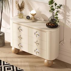 a white dresser sitting next to a potted plant