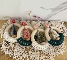 four christmas tree ornaments are on a doily