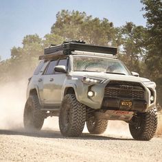 a toyota truck driving down a dirt road