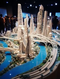 a model of a city is shown on display in a museum with people looking at it