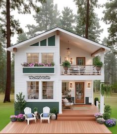 a small white house with green trim and windows on the second floor is surrounded by greenery