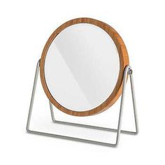 a round mirror sitting on top of a metal stand