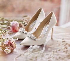 the bride's shoes are sitting next to flowers