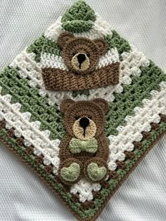 two crocheted teddy bears sitting on top of a blanket