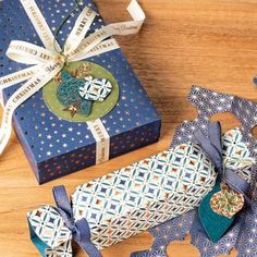 a blue gift box sitting on top of a wooden table next to two pieces of paper