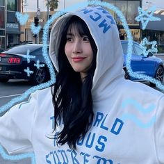 a woman with long black hair wearing a white hoodie and posing for the camera