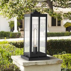 a black lantern sitting on top of a cement block