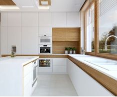 a modern kitchen with white cabinets and wood accents