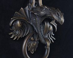 a metal dragon hanging on a black wall