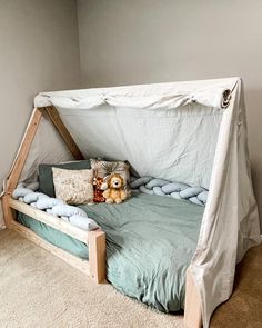 a child's bed with a canopy over it and stuffed animals on the bottom