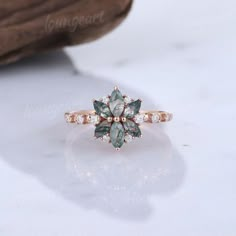 an engagement ring with green and white stones