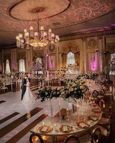 the bride and groom are standing in front of their wedding reception table set with flowers