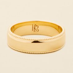 a yellow gold wedding band with beaded edges